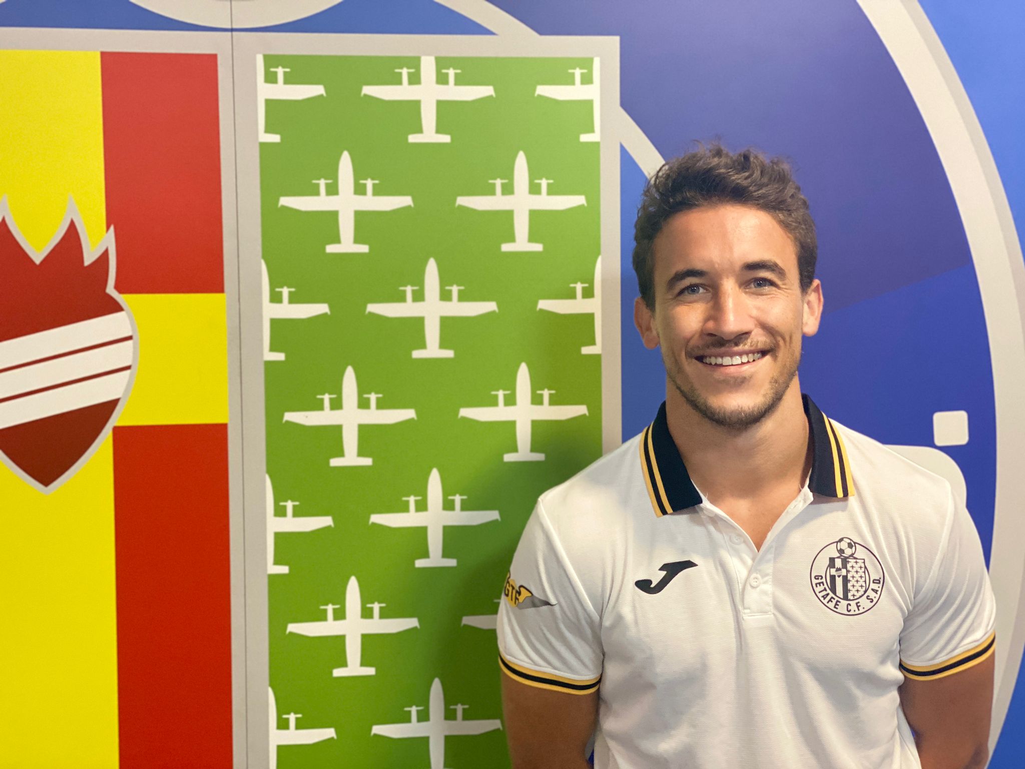 Luis Milla posa junto al escudo del Getafe (GETAFE CF)