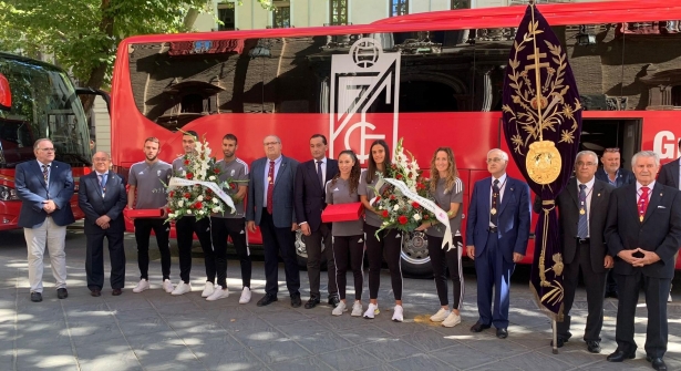 Miembros del Granada CF posan con las ofrendas florales a la entrada de la Basílica (JOSÉ VELASCO / GRJ)