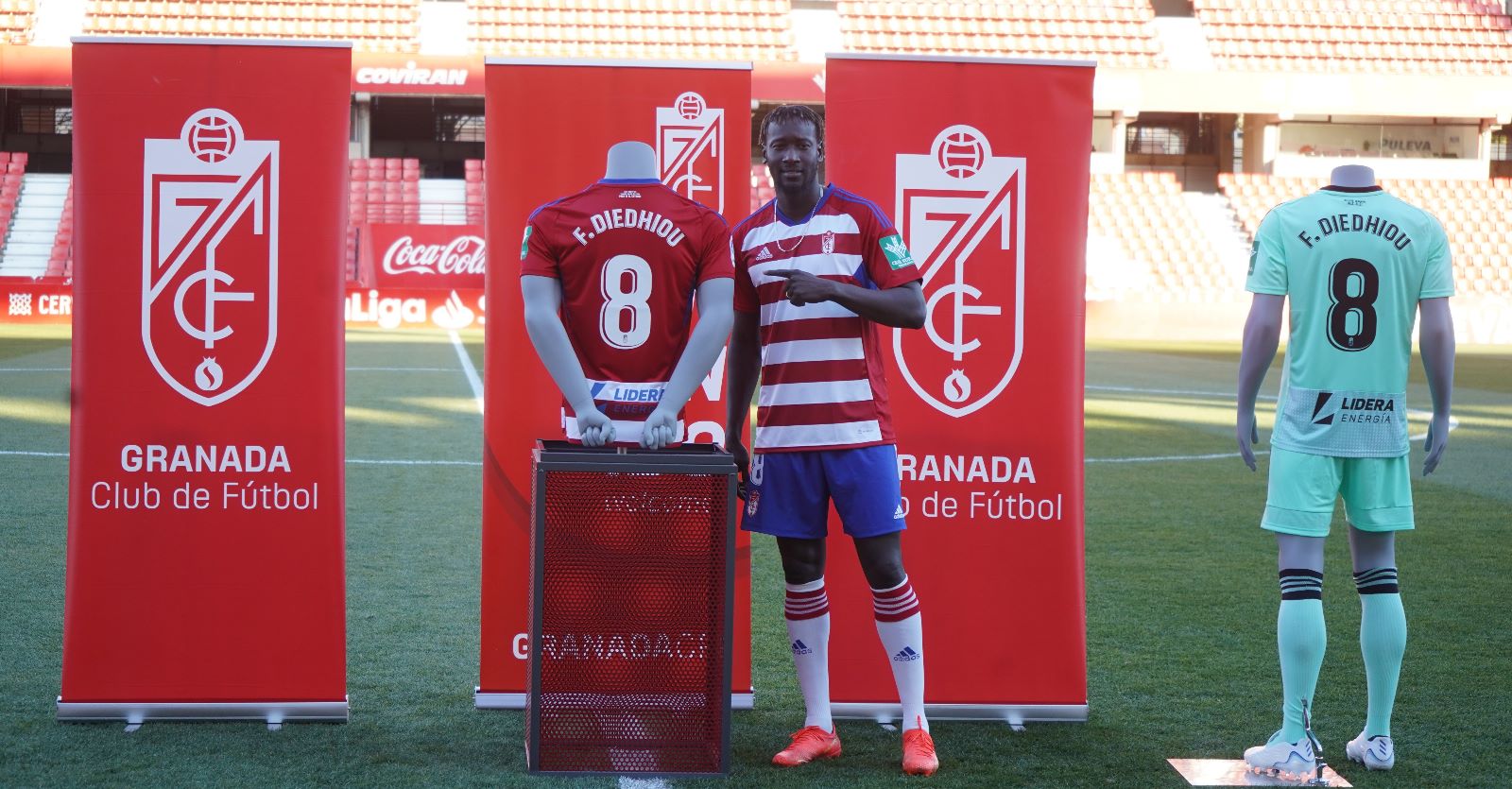 Famara posa sobre la lona de `Los Cármenes` junto a las camisetas del Granada (JOSÉ VELASCO)