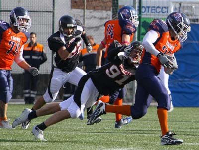 Un jugadores de los Lions intenta zafarse del placaje de un rival 
